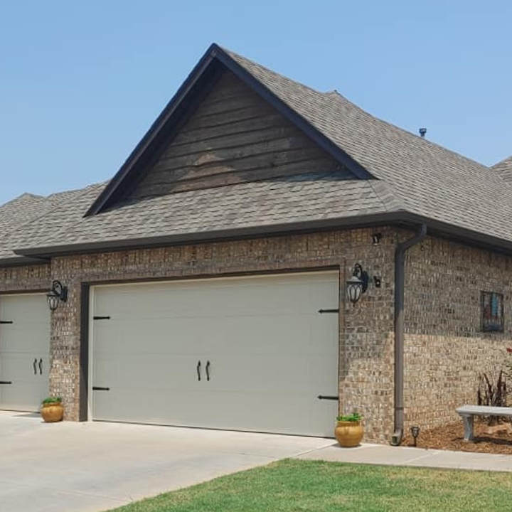 FAQs about total door solutions in oklahoma - image of new garage door install with white paneling with handles by Total Door Solution in Oklahoma