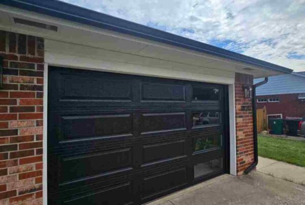 image of custom garage door. door is black with windows on the left panels by total door solutions in oklahoma city