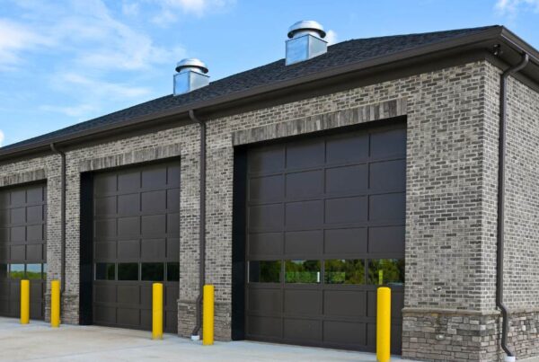 Residential vs Commercial Garage Doors What You Need to Know by total door solutions in oklahoma- image of 3 dark panel with windows garage doors